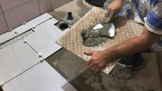 Footage of a bathroom reconstruction and a utility man putting ceramic tiles in a bathroom