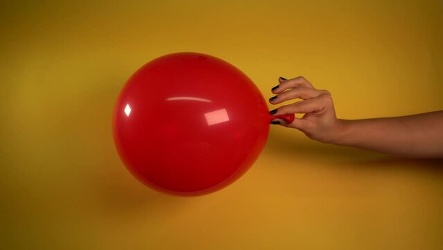 Beautiful red balloon deflating in woman's hand