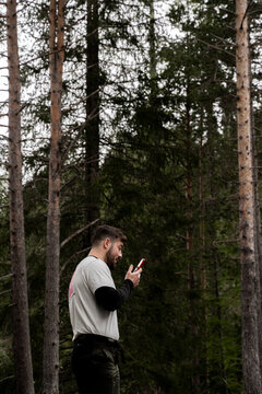 Chico mirando el m&oacute;vil en el Bosque , Dolomitas Alpes Italianos.