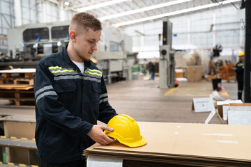 Caucasian engineer man with kraft paper cutting machine background 