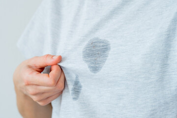 Unrecognized female showing at dirty grease stain on a gray t-shirt. daily life stain concept