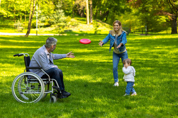Cute family playing frisbee in the park