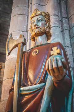 Close-up King holding rich apple, axe and a cross, indoors at St Magnus Cathedral, low angle view, Kirkwall, Scotland, vertical shot