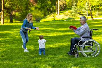 Parents a nd a cute kid playing frisbee and looking happy