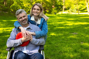 Fototapeta premium Cute couple hugging each other and looking happy in the park