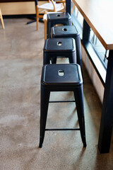 row of black metal bar stools