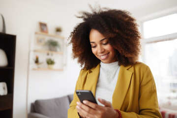 Beautiful black professional woman scrolling on her phone in her cozy home