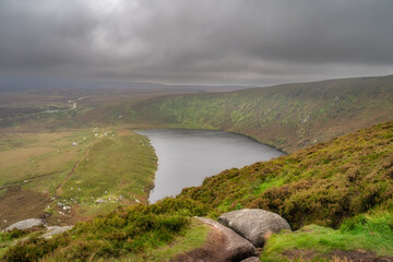 View on the lake Lough Bray from the top of the hill, covered in moody, dramatic storm clouds....