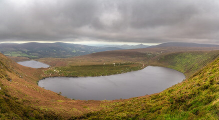 Panoramic view on upper and lower lakes Lough Bray, Sugarloaf and mountain range. Moody, dramatic...