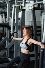 Close up of young woman doing exercises for arms at gym