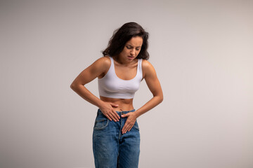Brunette millennial lady in pain suffering from period cramp