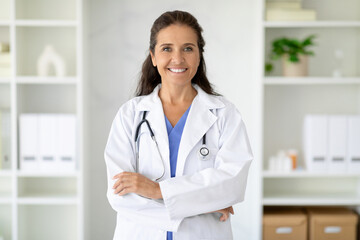Portrait of friendly smiling middle aged woman doctor