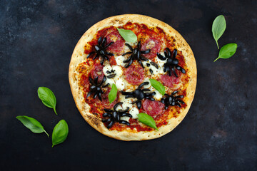 Traditionelle italienische Halloween Spinnen Pizza mit Salami, Mozzarella und Oliven serviert als...