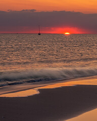 Sunset with orange sky and reflection on the beach and rings. Mediterranean, Camargue, Gard, France.