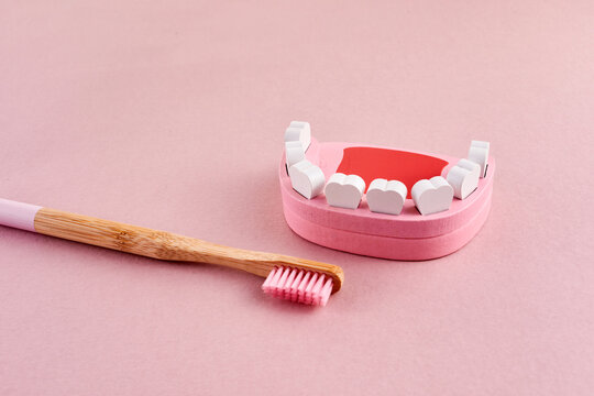 National brush day. Tooth with toothbrush on pink background. Dental health concept.