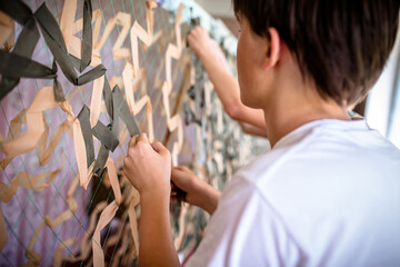War support: Ukrainian teens meticulously knitting camouflage net for troops