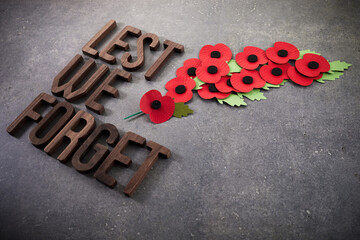 World War remembrance day. Red poppies on dark stone background. Lest we forget