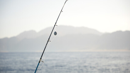 Close up of rod with fishing sinker on the fishing line ready to catch big fish in the sea....