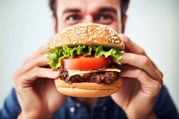 excited happy man eats meatless plant based vegan burger with tomato, lettuce, onion, soya protein burgers, meat free healthy food close up at home. - obrazy, fototapety, plakaty