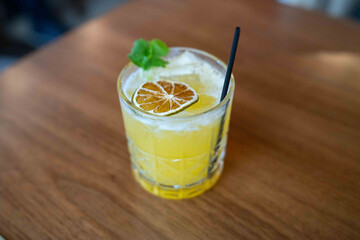 yellowish tequila cocktail served on the rocks with green garnishes at a fine dining restaurant