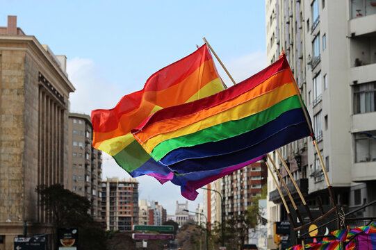 bandeiras lgbt tremulando nas ruas da cidade em dia de marcha pela diversidade e orgulho gay.