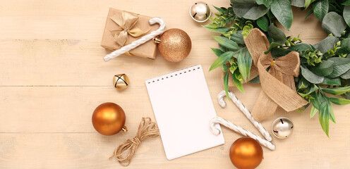 Blank paper calendar with gift box and Christmas decorations on wooden background