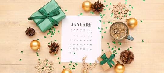 Calendar for January with cup of coffee, gifts and Christmas decorations on wooden background