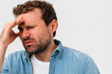 Obraz premium Man in blue jeans shirt with short curly hair with severe headache