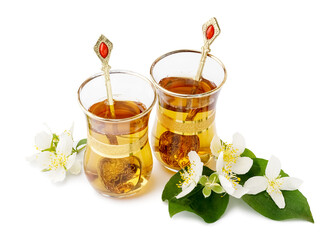 Cups of tea and beautiful jasmine flowers on white background