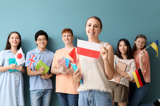 Young students of language school with flags on blue background