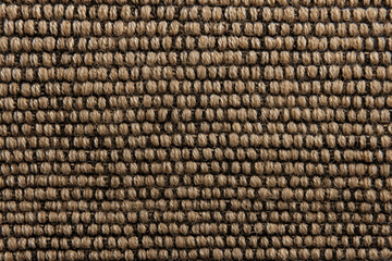 Closeup of tweed with a textured surface, composed of small, tightlywoven interlocking threads that create a durable and sy weave.
