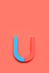 Horseshoe shaped magnet on red background