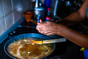A brown-skinned person is going to add garlic to the pan.
