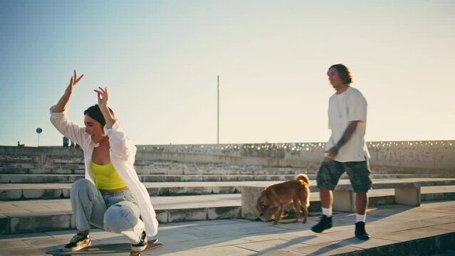 Cute skaters learning skateboard tricks street. Couple having fun riding skate