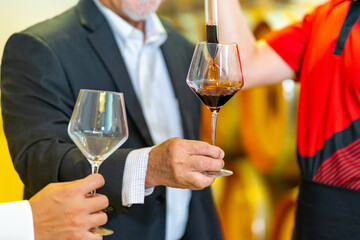 Group of Man and woman sommelier tasting red wine in wooden barrel at vintage wine cellar at wine factory. Winery, wine shop, brewery liquor business manufacturing industry and winemaker concept.