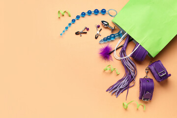 Green shopping bag with sex toys and ribbons on beige background