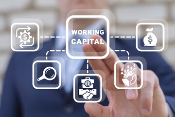 Businessman using virtual touch interface presses inscription: WORKING CAPITAL. Working capital business concept.