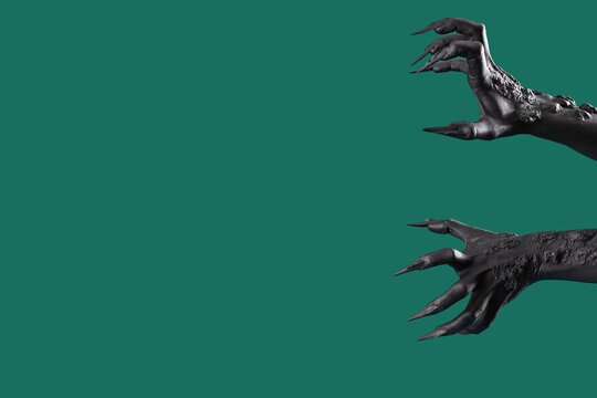 Black Hands Of Witch With Claws On Green Background. Halloween Celebration