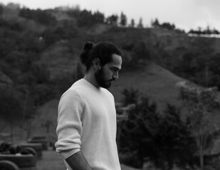 hombre de cabello largo con paisaje montañoso de fonso y sueter blanco