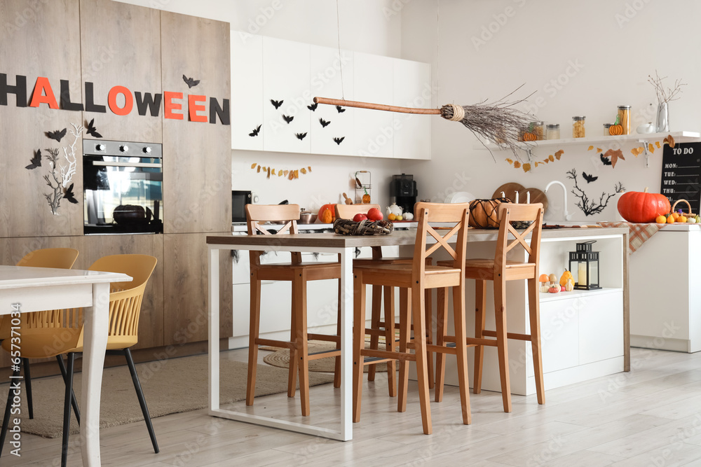 Poster Interior of light kitchen decorated for Halloween with white counters and dining table