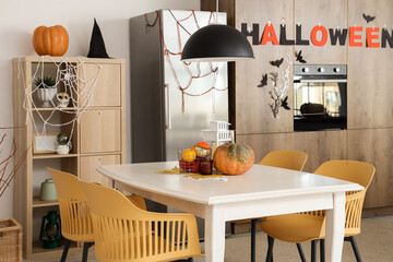 Interior of light kitchen decorated for Halloween with dining table