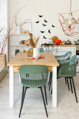Interior of light kitchen decorated for Halloween with dining table