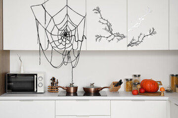 Interior of light kitchen decorated for Halloween with white counters