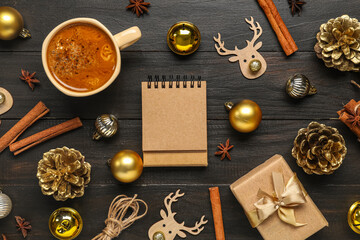 Blank paper calendar, gift box, cup of coffee and Christmas decorations on black wooden background