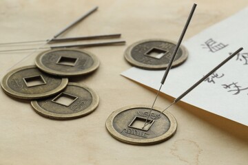 Acupuncture needles, Chinese coins and sheet with characters on paper, closeup