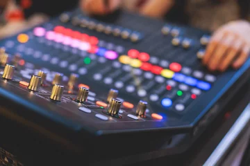 Fotobehang View of lighting technician operator working on mixing console workplace during live event concert on stage show broadcast, light mixer controller panel, sound technician with professional equipment © tsuguliev