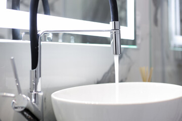 Chrome faucet with white ceramic sink in the bathroom