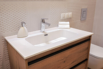 Fototapeta na wymiar Chrome faucet with white ceramic sink in the bathroom
