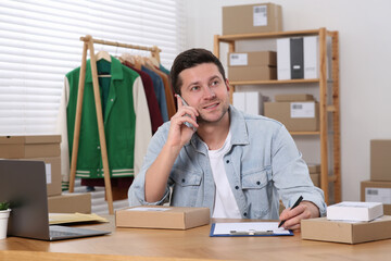 Seller talking on phone while working in office. Online store