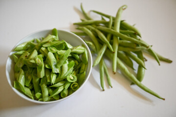 bunch of green beans on a bowl, isolated white background. Buncis or Phaseolus vulgaris  or Phaseolus esculentus.